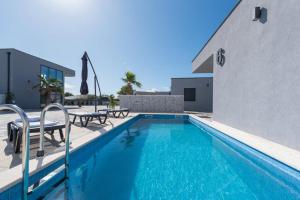 维尔More Exclusive Villas and Spa的一座带两把椅子的游泳池以及一座建筑
