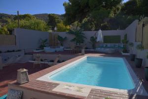 uma piscina num quintal com uma mesa e cadeiras em Arsinoe Luxury Villa em Salamís
