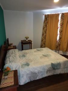 1 dormitorio con cama, mesa y ventana en Complejo Las Palmeras en Tandil