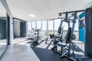 einen Fitnessraum mit Kardiogeräten in einem Gebäude mit Fenstern in der Unterkunft More Exclusive Villas and Spa in Vir