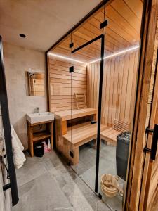 een badkamer met een sauna met een wastafel en een bad bij Chalet Dakota, Pied des pistes, 15 pers, La Plagne in Plagne 1800