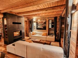 a living room with white couches and a fireplace at Chalet Dakota, Pied des pistes, 15 pers, La Plagne in Plagne 1800