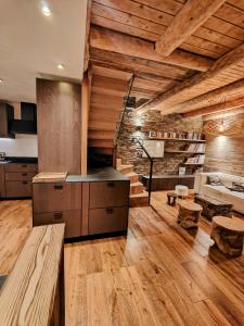 a kitchen with wooden floors and a stone wall at Chalet Dakota, Pied des pistes, 15 pers, La Plagne in Plagne 1800