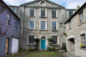 an old stone building with a blue door at The Colour House, Kendal Getaway in Kendal