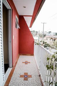 a balcony with a red wall and a tile floor at Pousada do Anhangava in Quatro Barras