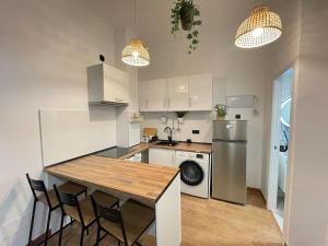 een keuken met een tafel en stoelen en een koelkast bij HomeStay Lopez Pando in Madrid