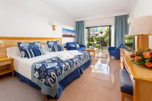 モロ・デル・ハブレにあるMUR Faro Jandia Fuerteventura & Spaのベッド、デスク、椅子が備わるホテルルームです。