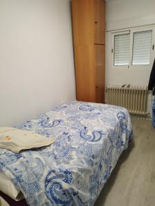 波蘇埃洛－德阿拉爾孔的住宿－Habitación en Pozuelo de Alarcón，一张位于一间蓝色和白色毯子的房间内的床铺