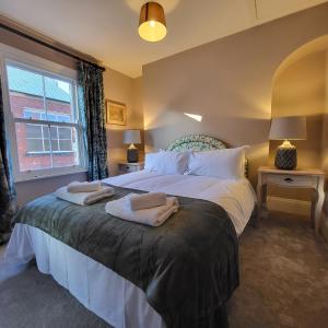 a bedroom with a large bed with towels on it at Ogleforth in York