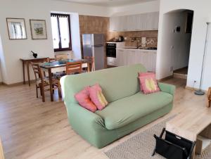 een woonkamer met een groene bank met roze kussens bij Al Piccolo Borgo Antico in Torri del Benaco