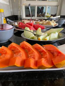 a buffet with plates of fruit on a table at Pousada Vitória da Vila in Brasília