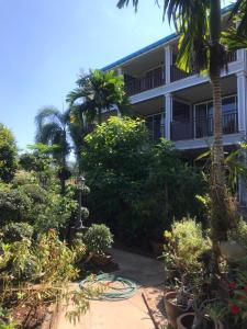 un jardín frente a un edificio con plantas en Pratum Resort, en Khao Lak