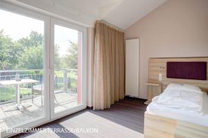 a hotel room with a bed and a balcony at Stössels Hotel & Restaurant in Altenmedingen