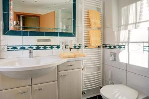 a bathroom with a sink and a toilet at Stössels Hotel & Restaurant in Altenmedingen