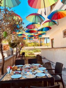 a table with plates of food and colorful umbrellas at Aysultan Stone House in Uçhisar
