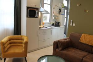 a living room with a couch a chair and a kitchen at Le gite des 3 mousquetaires in Amboise