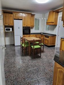 a kitchen with a table and chairs and a white refrigerator at Apartamento La Carrera in Adra