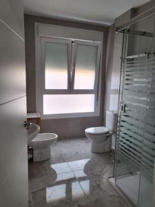 a bathroom with two toilets and a window at Apartamento La Carrera in Adra