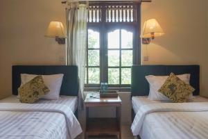 Postel nebo postele na pokoji v ubytování Ubud Kerta City Hotel
