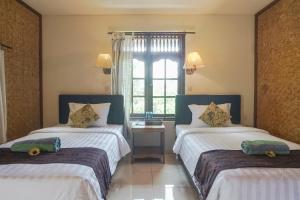 Postel nebo postele na pokoji v ubytování Ubud Kerta City Hotel