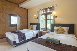 Postel nebo postele na pokoji v ubytování Ubud Kerta City Hotel