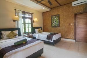 Postel nebo postele na pokoji v ubytování Ubud Kerta City Hotel
