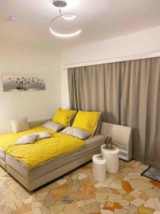 1 dormitorio con 1 cama con sábanas amarillas y manta amarilla en Ferienwohnung Studio Belvedere, en Brezzo