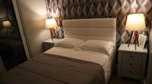 1 dormitorio pequeño con 1 cama y 2 lámparas en Mirante da Figueira - Suítes para temporada en Angra dos Reis