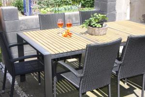 een houten tafel met stoelen en twee glazen wijn bij Haus Bella Altendiez in Altendiez