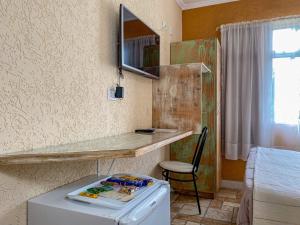 a room with a refrigerator and a table with a mirror at Pousada do Anhangava in Quatro Barras
