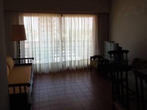 una sala de estar con una gran ventana con cortinas en Dpto en Miramar, 2 amb, ubicación ideal, cochera. en Miramar
