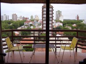 3 sillas y una mesa en un balcón con vistas en Dpto en Miramar, 2 amb, ubicación ideal, cochera. en Miramar