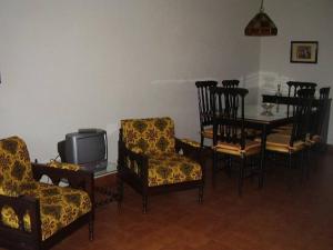 sala de estar con sillas y mesa con TV en Dpto en Miramar, 2 amb, ubicación ideal, cochera. en Miramar