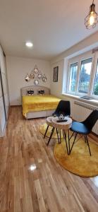 une chambre avec un lit, une table et des chaises dans l'établissement Apartment GOLD STAR, à Sarajevo