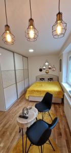 une chambre avec un lit, deux chaises et une table dans l'établissement Apartment GOLD STAR, à Sarajevo 8 autres photos