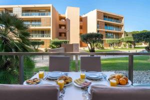 a table with food and glasses of orange juice on a balcony at Salgados Beach House 2-Bedroom & 7 Pools in Guia