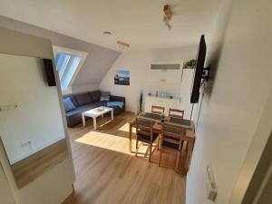 a living room with a table and chairs and a living room at Kiel-Russee Familienwohnung, Lademöglichkeit, Co2 Frei in Kiel