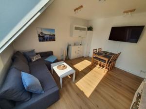 a living room with a blue couch and a table at Kiel-Russee Familienwohnung, Lademöglichkeit, Co2 Frei in Kiel