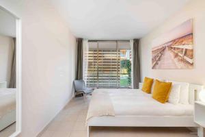 a white bedroom with a bed and a window at Salgados Beach House 2-Bedroom & 7 Pools in Guia