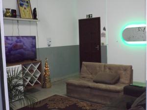 a living room with a couch and a tv at Hostel Lize in Cumbica