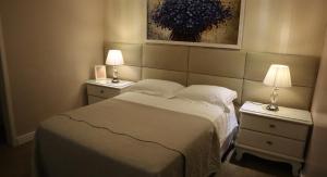 um quarto com uma cama e duas mesas de cabeceira com candeeiros em Mirante da Figueira - Suítes para temporada em Angra dos Reis