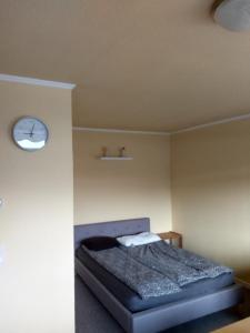 um quarto com uma cama e um relógio na parede em Kati Appartement em Bad Hönningen
