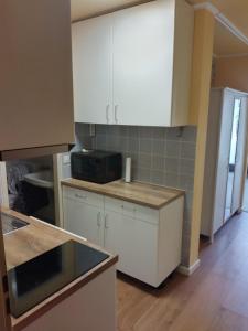 uma cozinha com armários brancos e uma bancada em Kati Appartement em Bad Hönningen