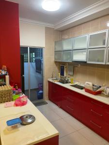 a kitchen with red cabinets and a counter top at Oug Parklane 3br2b Spacious House for a big family in Kuala Lumpur