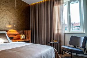 a bedroom with a bed and a chair and a window at Calma Luxury Rooms in Split +129 photos