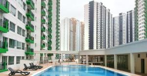 a swimming pool in the middle of a building with tall buildings at Oug Parklane 3br2b Spacious House for a big family in Kuala Lumpur
