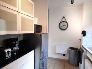 uma cozinha com um frigorífico e um relógio na parede em Ty Cocoon- Appartement avec terrasse et parking privé em Quimper