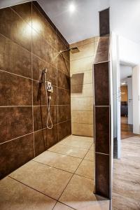 Łazienka z prysznicem wyłożona jest brązowymi kafelkami. w obiekcie Moderne Ferienwohnung Hildburghausen - FeWo 1 w mieście Hildburghausen