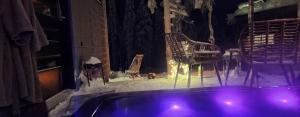 um quarto com uma banheira e uma cadeira na neve em Levi Secret Igloo Revontuli em Sirkka