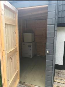 eine Garage mit einer Tür, die zu einem Gebäude führt in der Unterkunft Riverside Hideaway in Kincraig